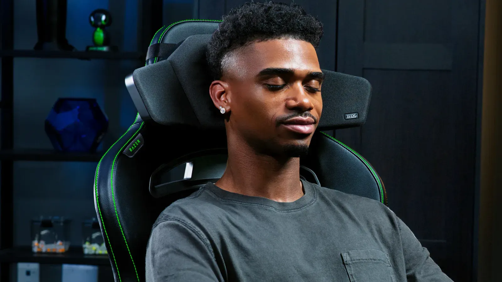 Razer Clio-højttaler monteret på en gamingstol med LED-lys i baggrunden.