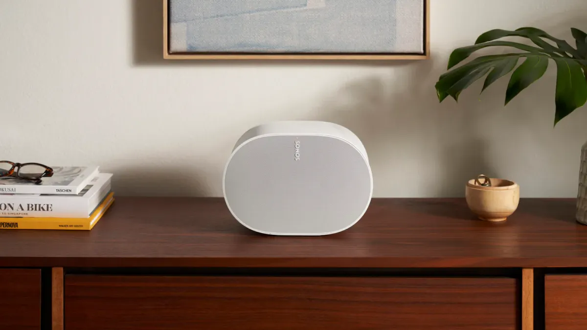 En hvid Sonos Era 300-højttaler på en træskænk i en moderne stue.